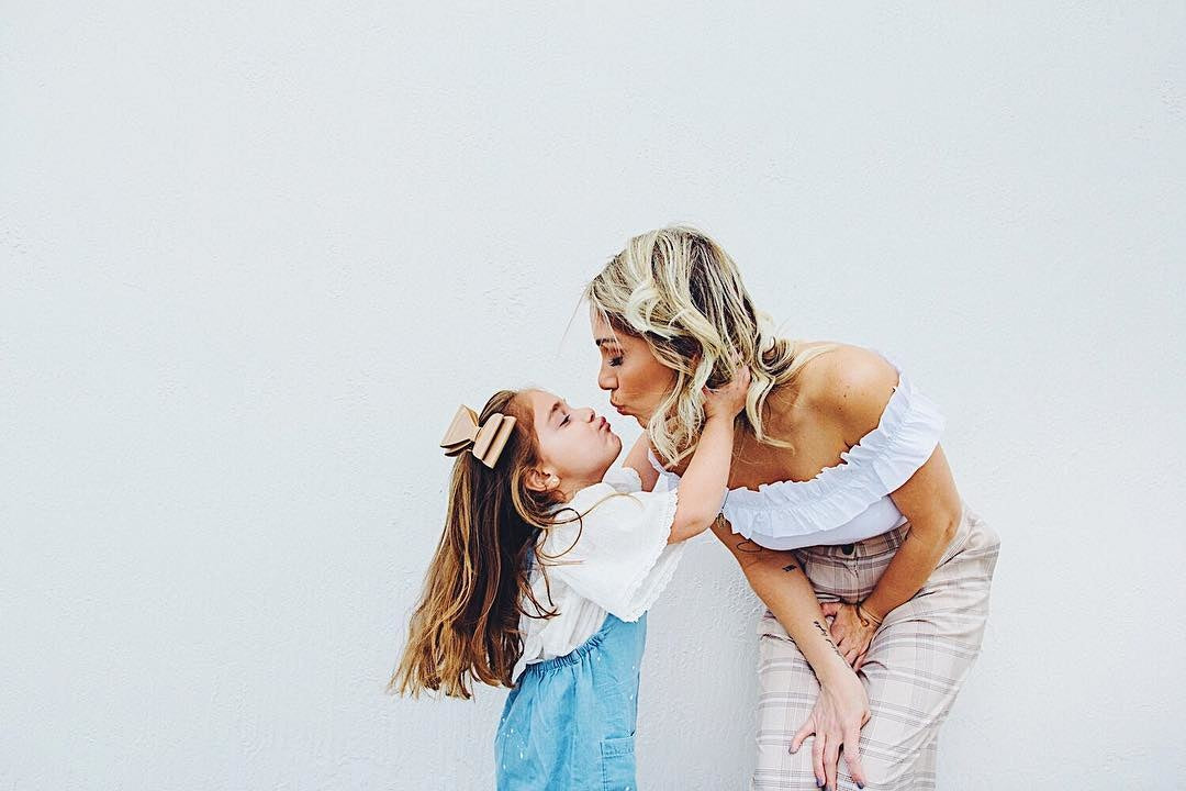 young mother and little girl going to kiss