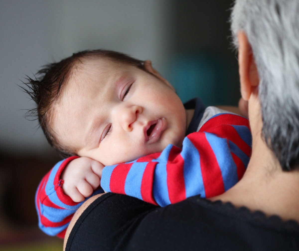 baby sleeping on grandparent's shoulders