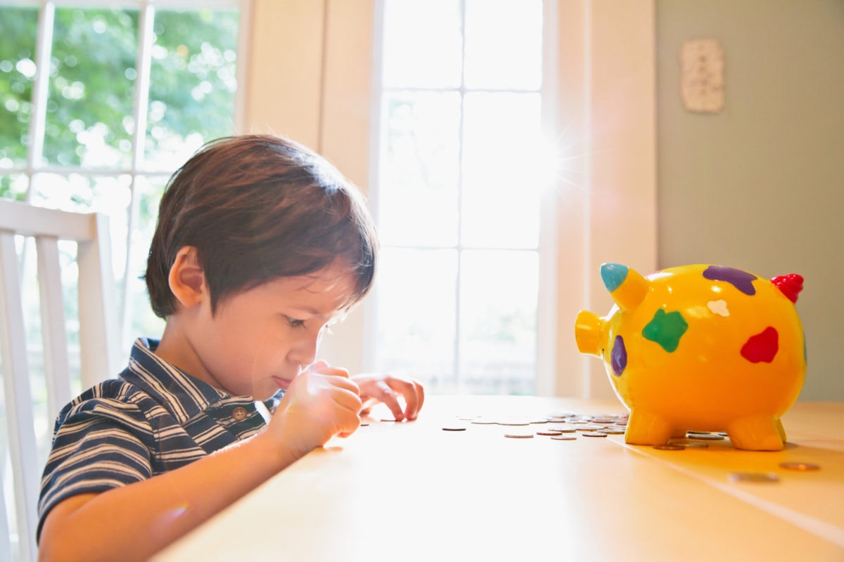 young boy counting his piggy bank money