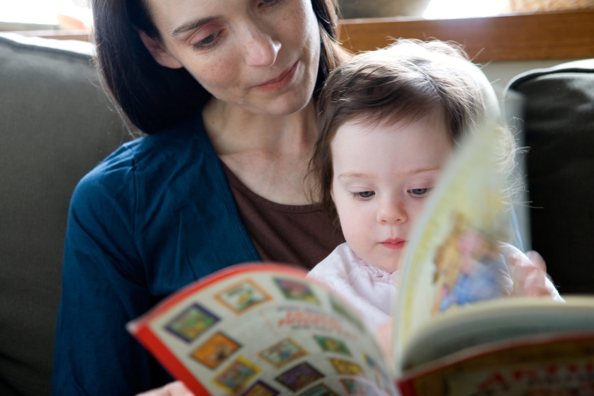 Mother reading book with cute baby girl