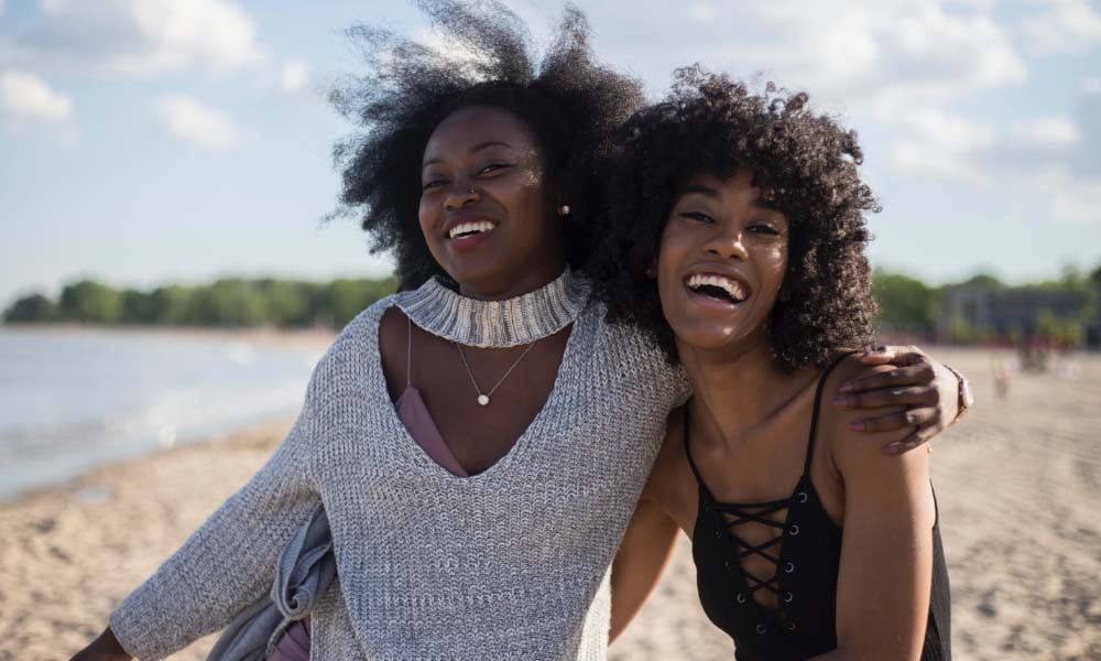 due donne che sorridono sulla spiaggia
