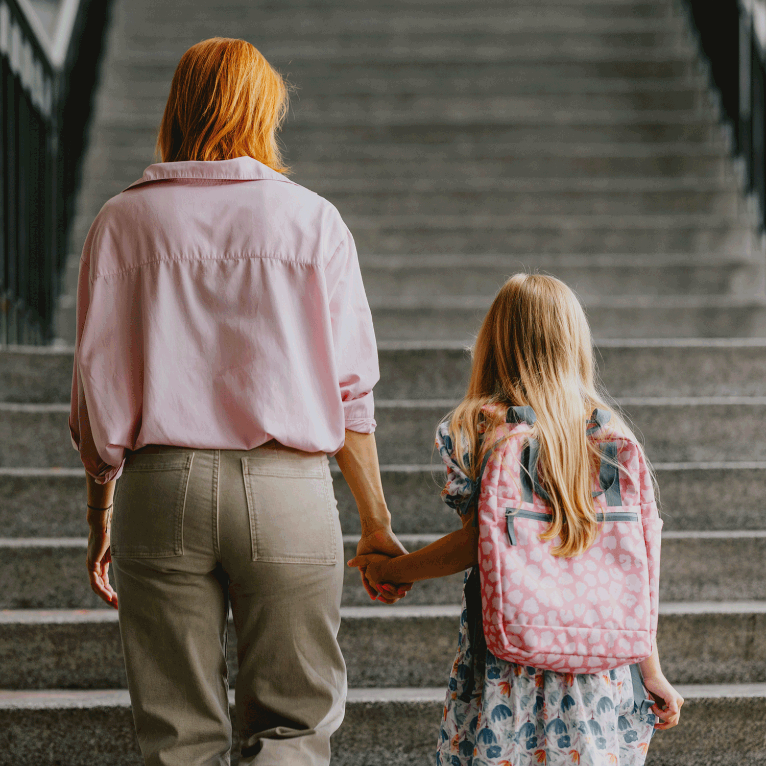 Woman and child holding hands on a set of stairs