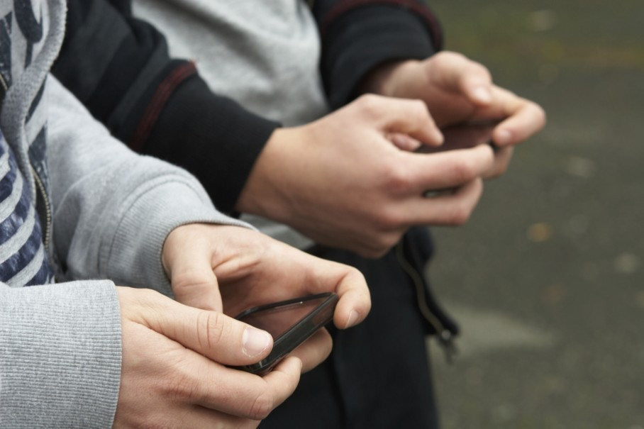 two young boys playing with mobile phones