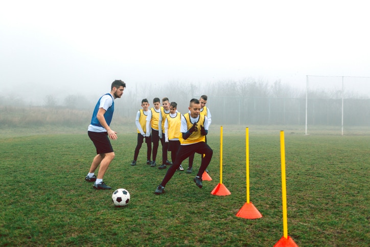 Children practicing football with coach