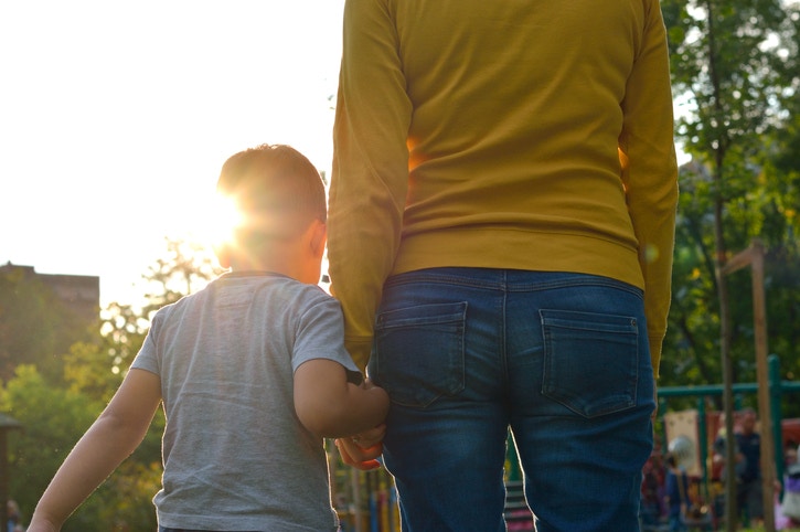 A child walking with mother holding hand