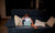 little girl sitting on sofa watching movie on tablet