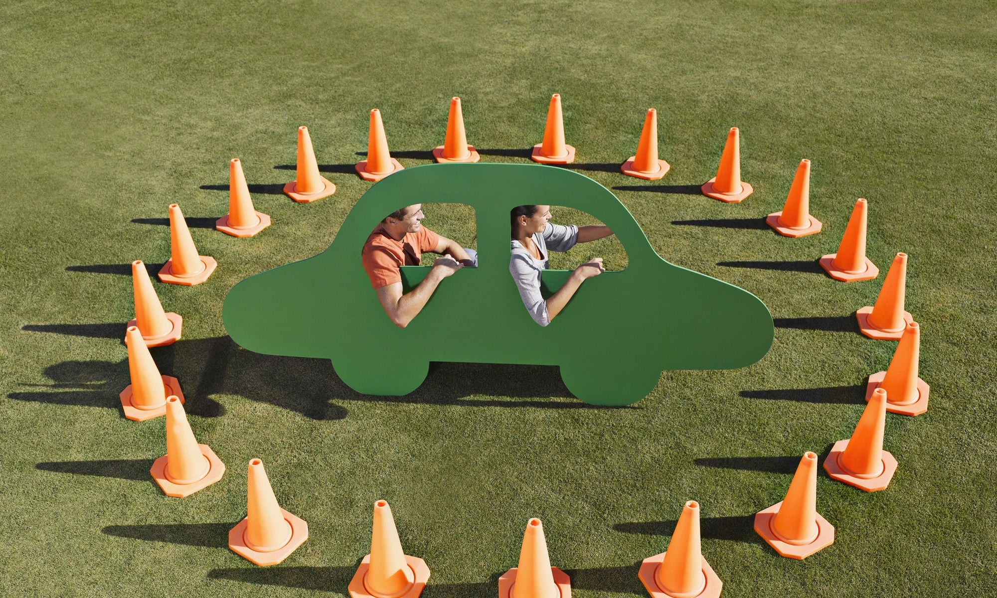 couple sitting in a car image surrounded by traffic cones