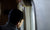 boy sitting on the seat looking out an airplane window while flying