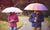 men and women covering face with an umbrella