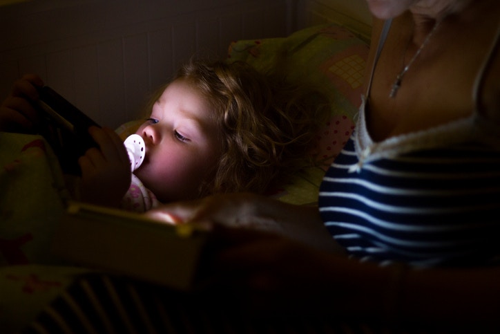 cute baby watching cartoons in a mobile phone at night