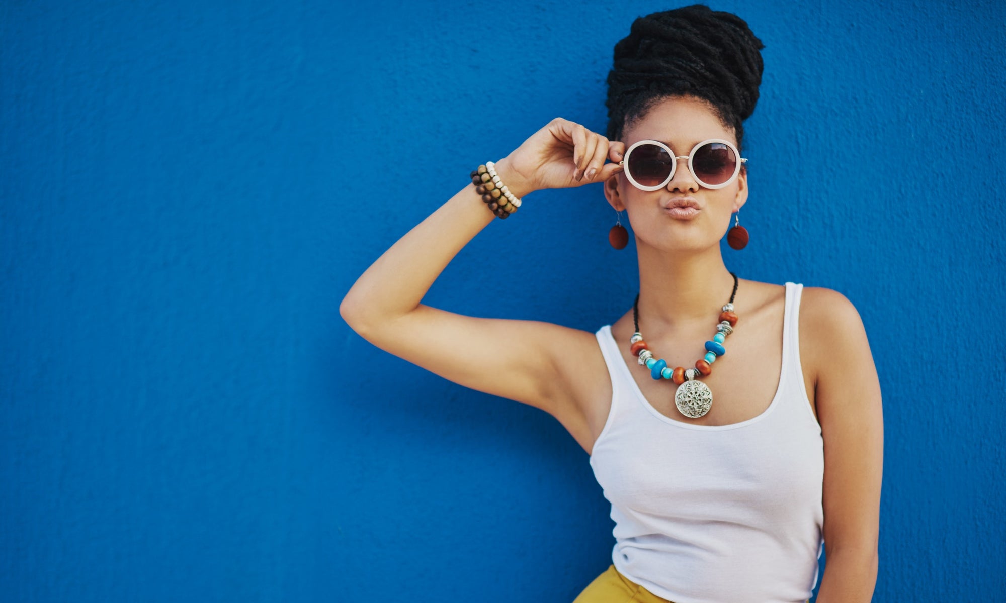 female in front of blue wall with kissing face