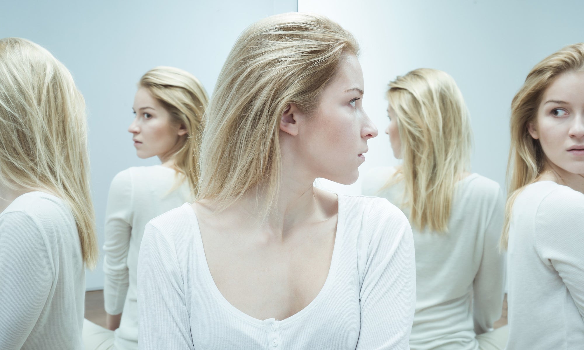 blond teenage girl staring at her reflection