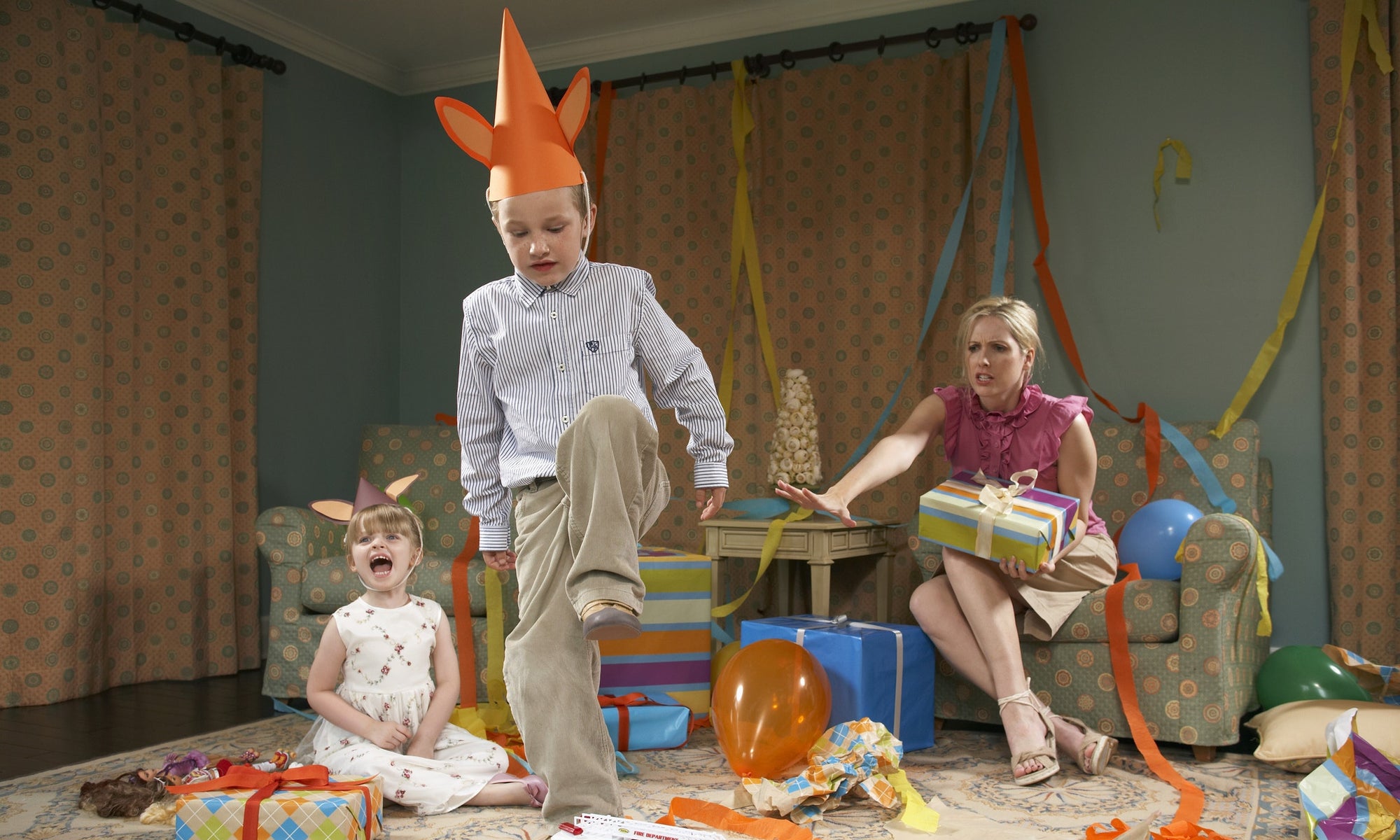 angry boy stepping on birthday gifts and worried mother