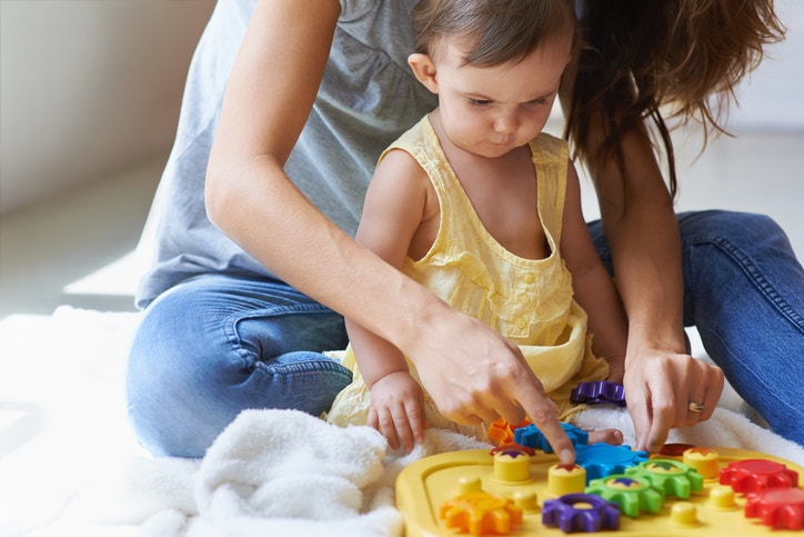 Mother and daughter playing with toy on floor