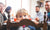 Parents teaching table manners to preschoolers