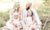 happy family sitting on flower field in park on a sunny day