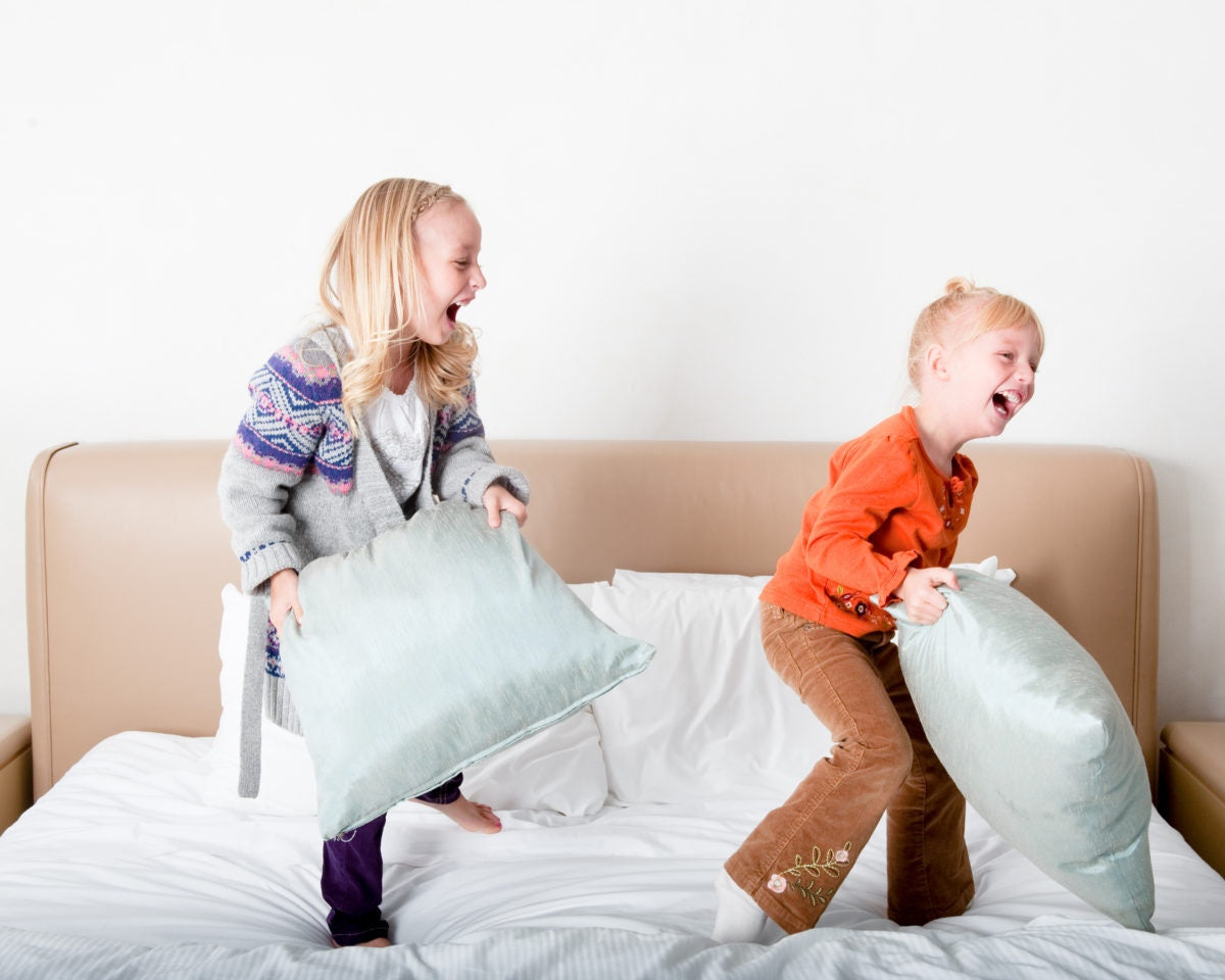 sisters playing with pillows