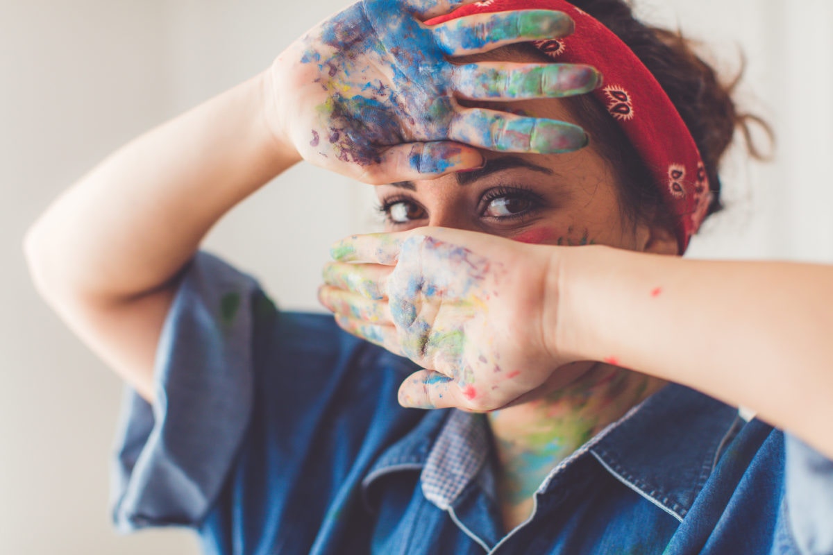 A girl is showing her hands with full of colours