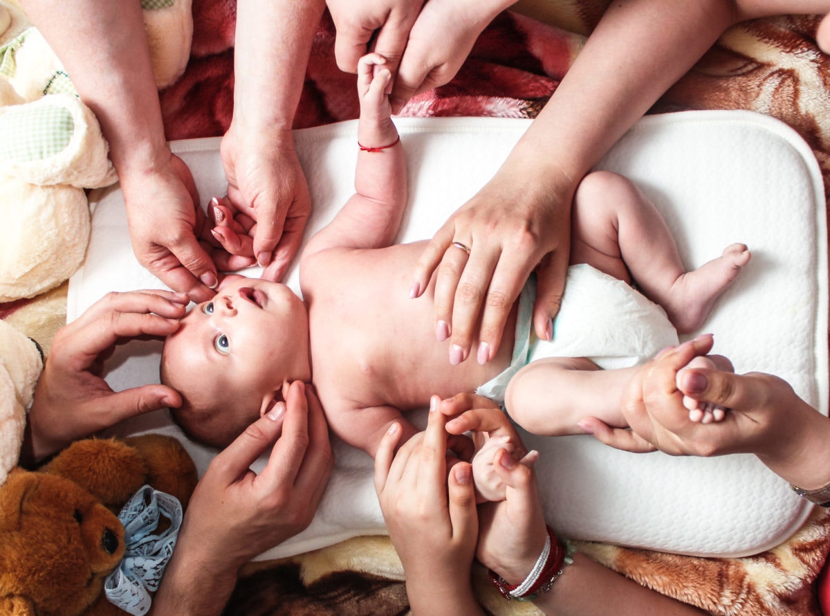 Family members showing happiness to a new born baby