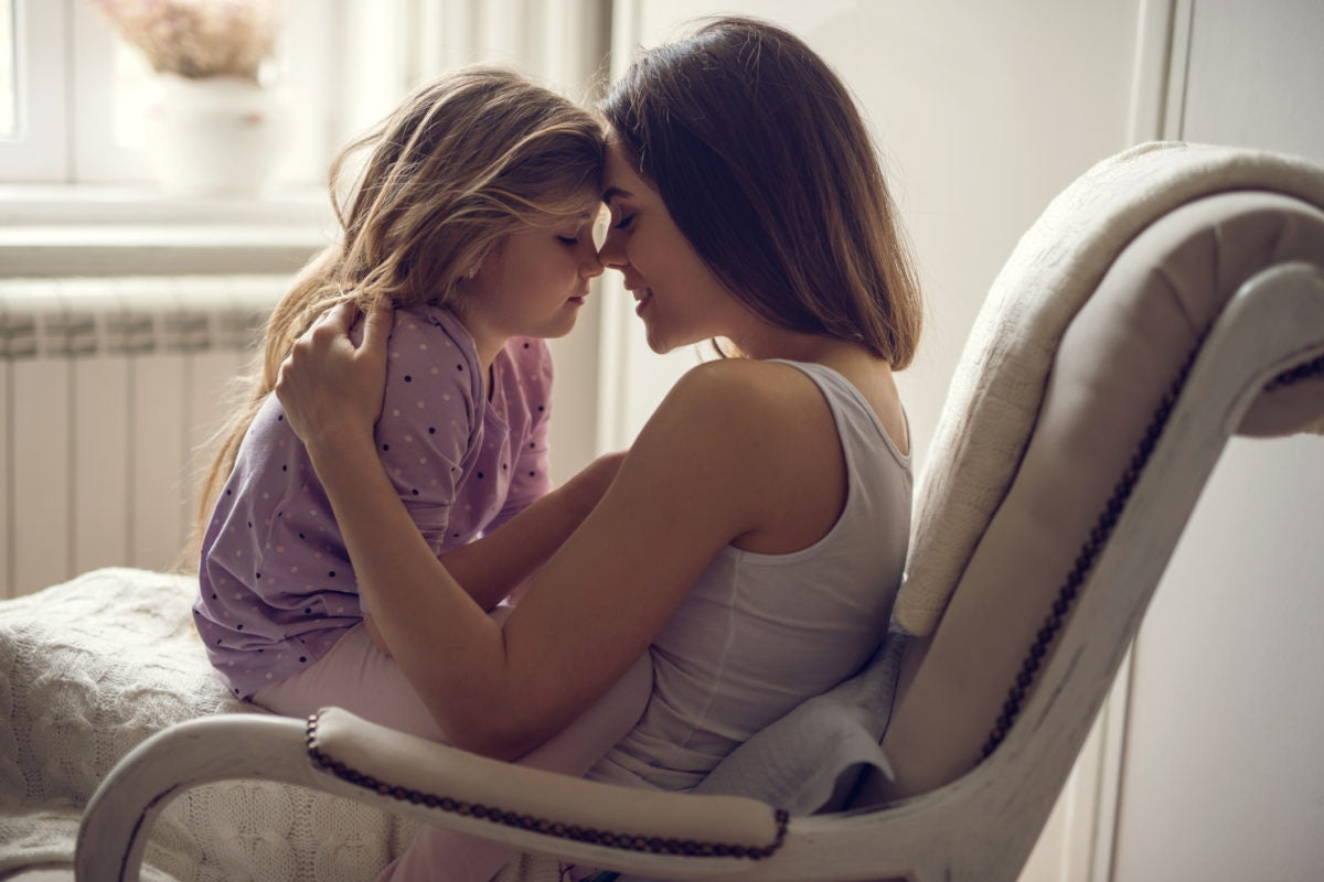 young mother with her daughter sit on a chair