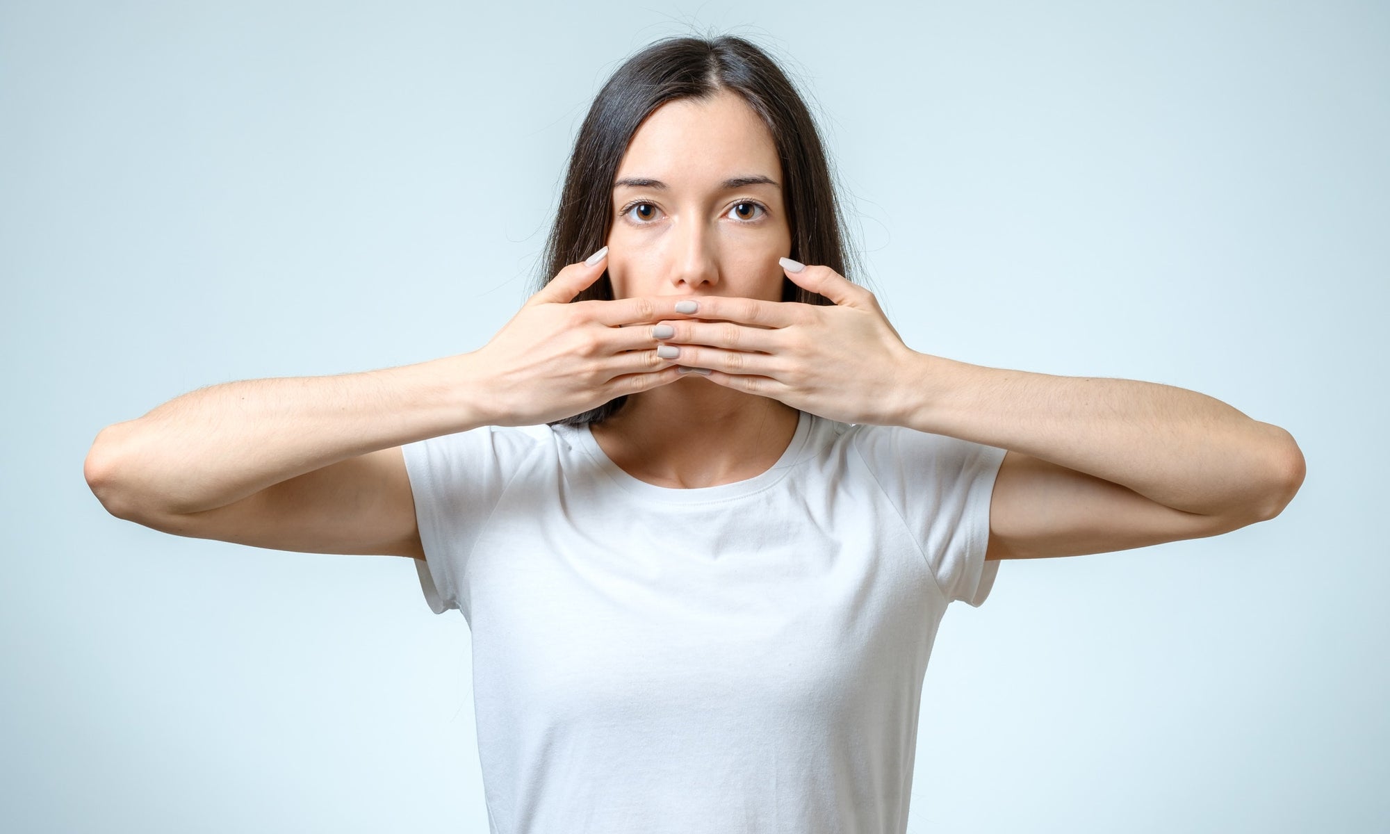 young woman covering her mouth with her hands