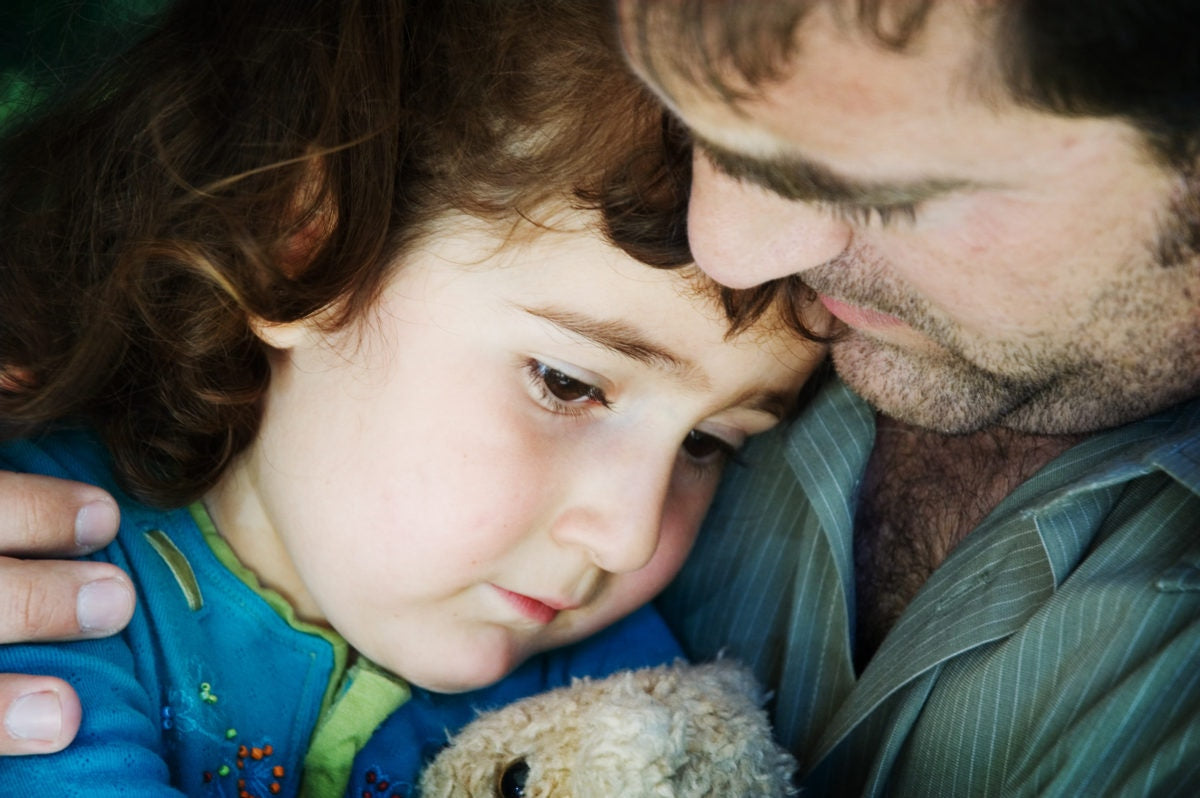 sad young girl Lying On Father In Park