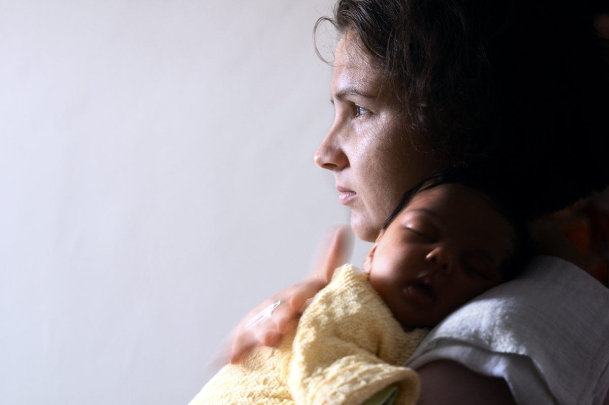 A baby sleeping on her mothers shoulder