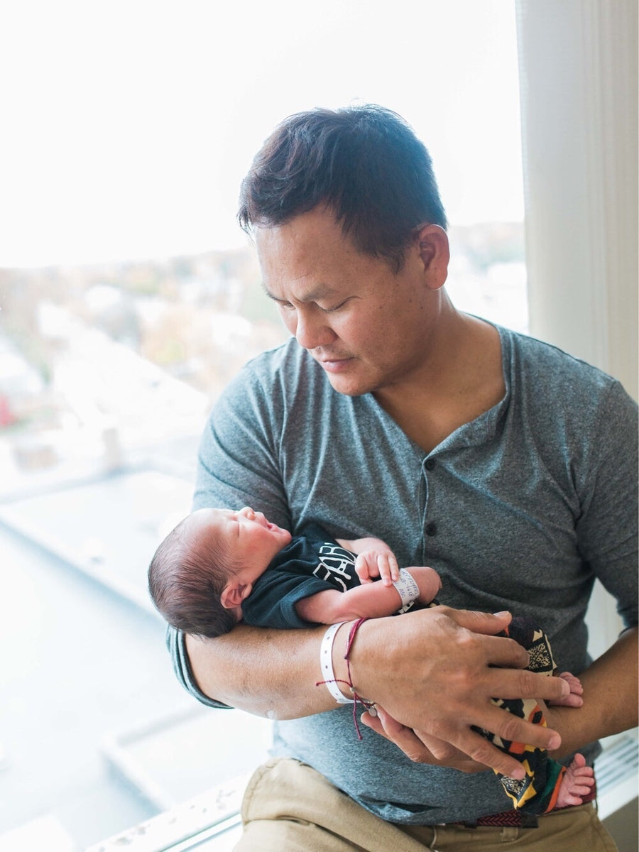 Happy father holding newborn baby in his arms