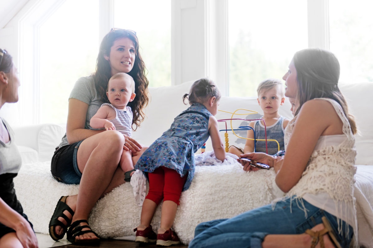 Mothers with their children in the room talking and playing