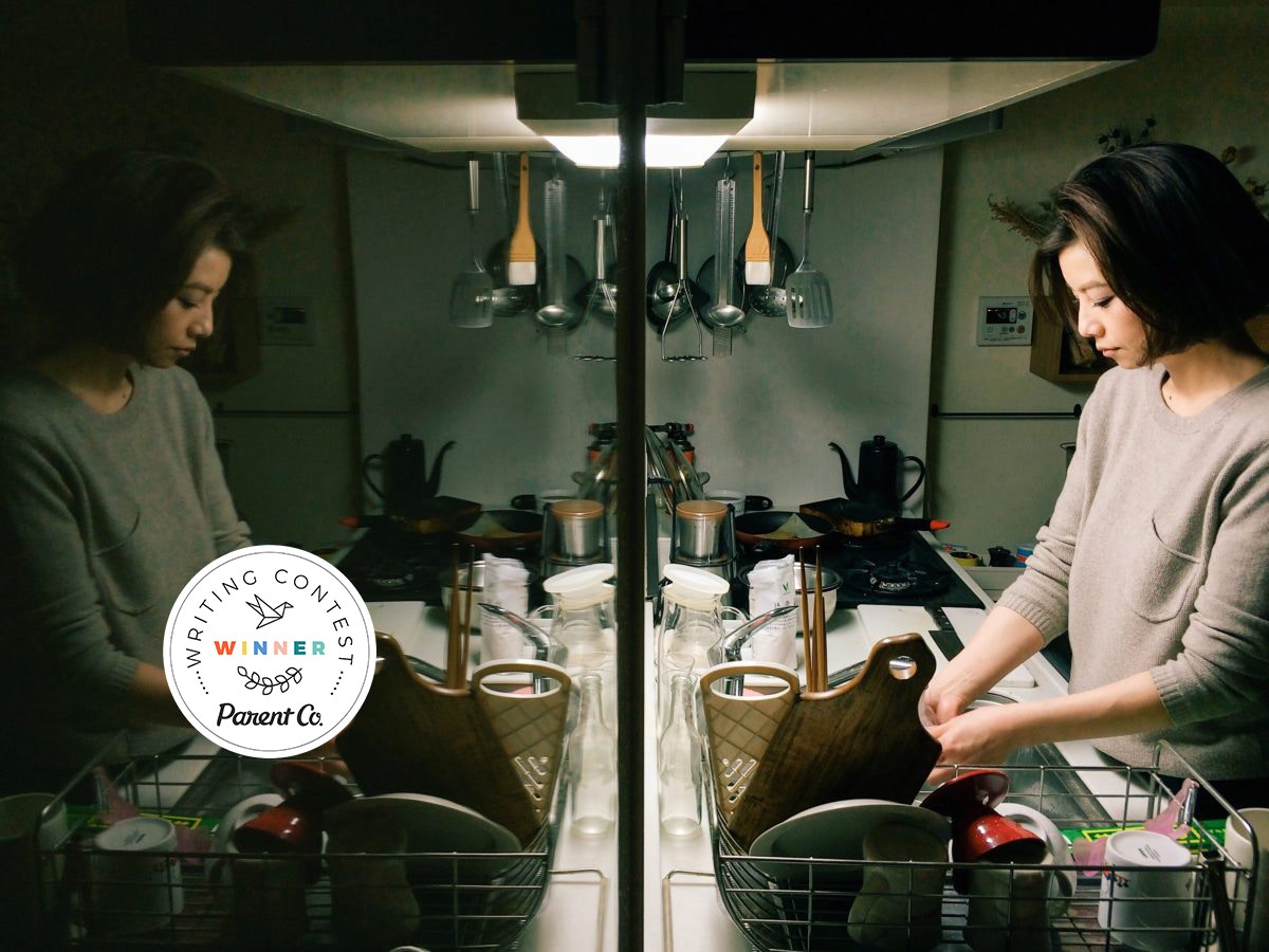 Reflection of a lady washing dishes