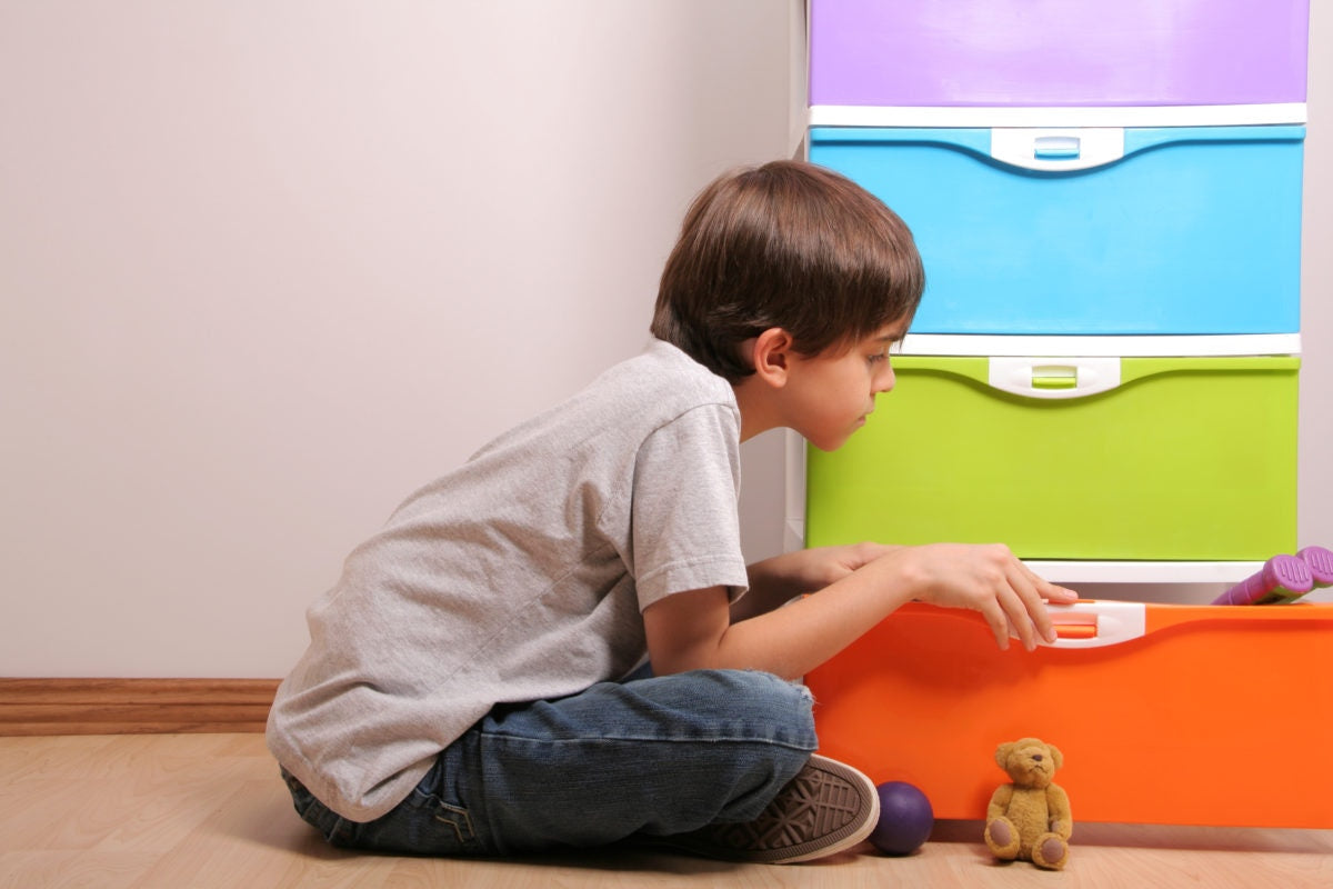 boy siting looking into multicolored drawers