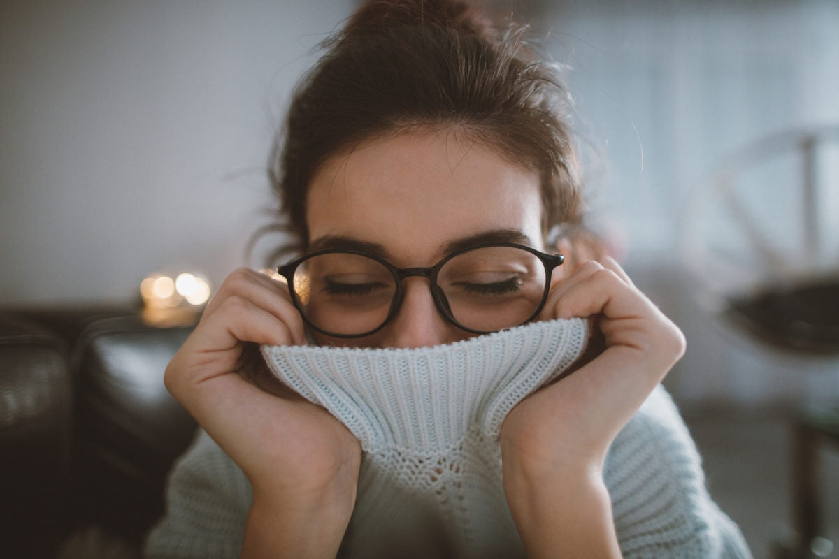 women with sweater covering her mouth