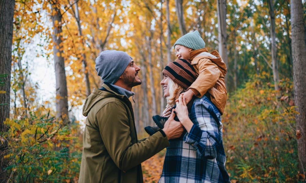 family of three on a walk in the forest