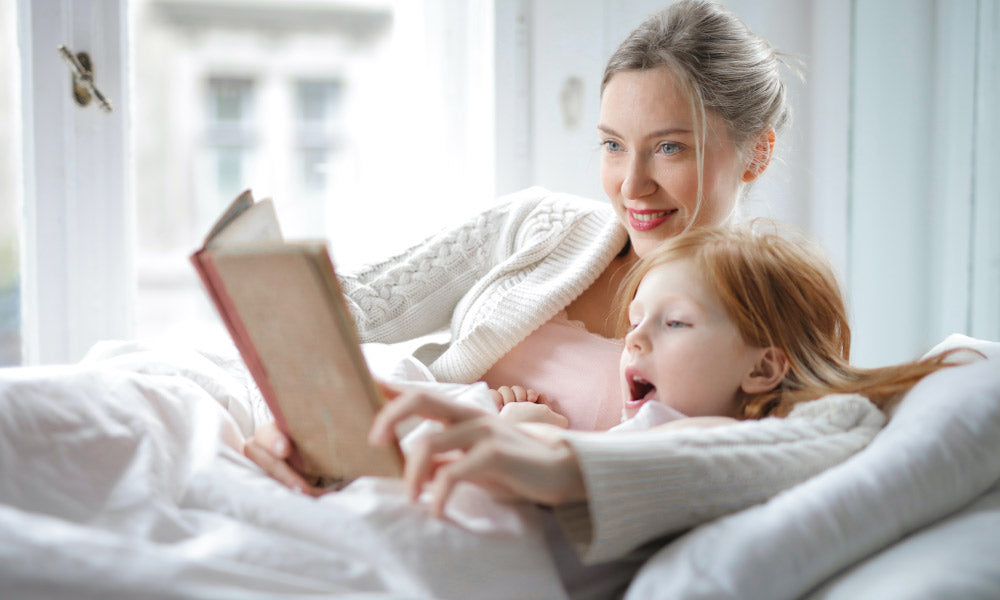 mamma e figlia che leggono un libro a letto