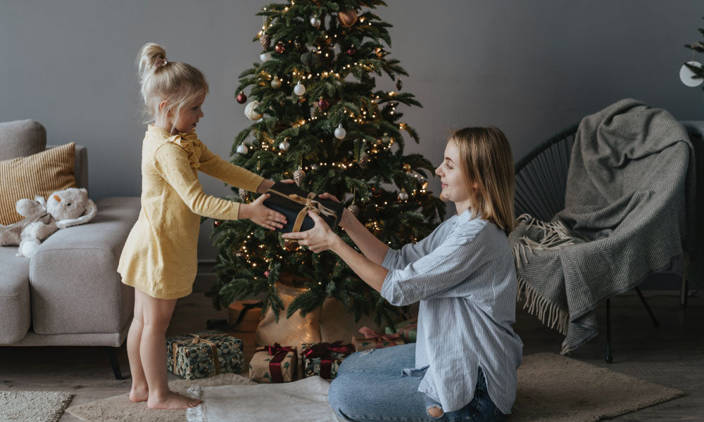 mother handing daughter a christmas gift