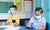 two kids at a desk wearing masks